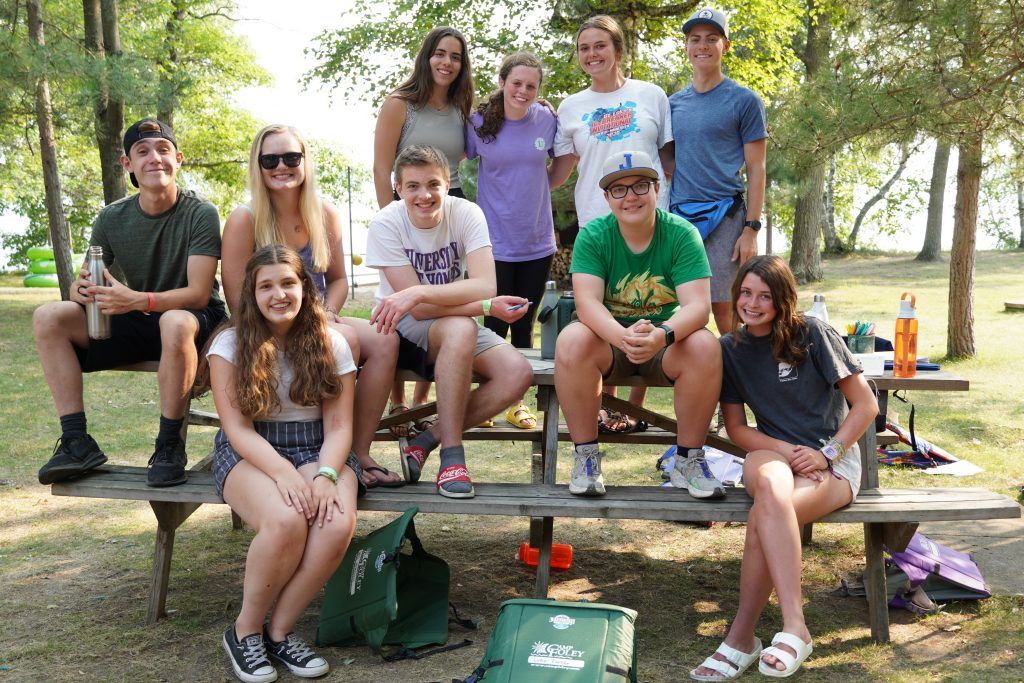 Group of teenagers engaged in teamwork activities at a coed summer camp