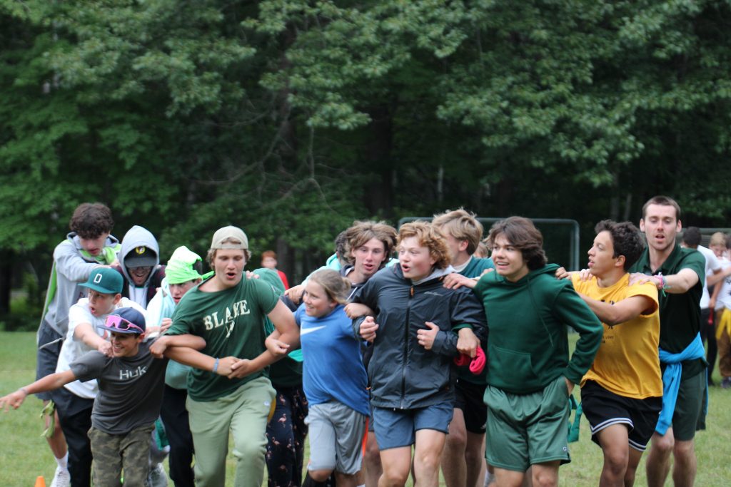 boy campers with arms linked running in a straight line 