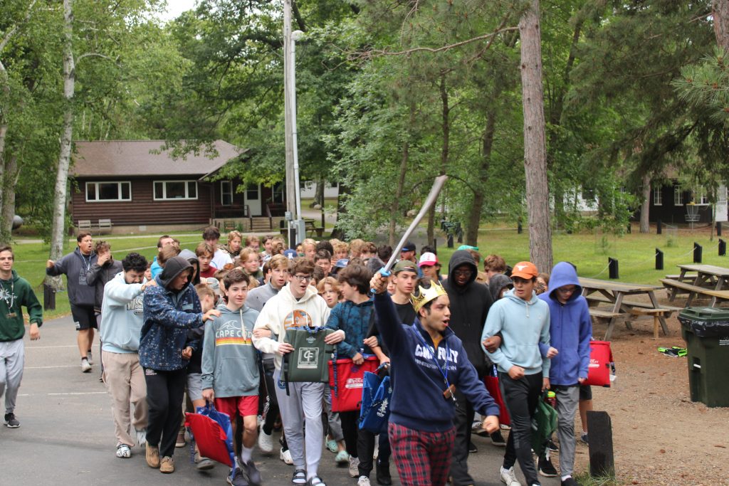 male counselor with foam sword leading a group of boy campers at Camp Foley 