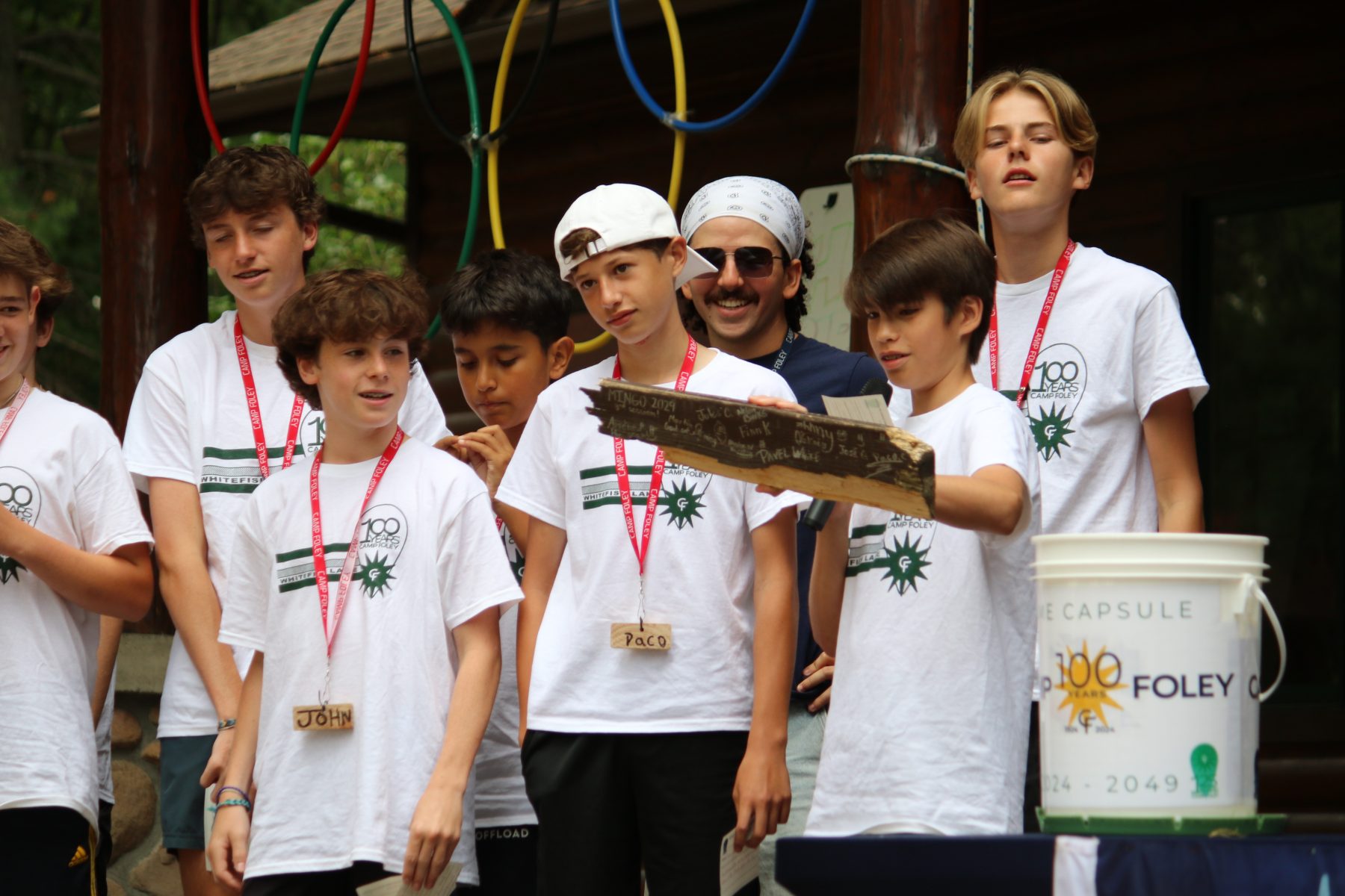 A group of boys hold up a piece of wood