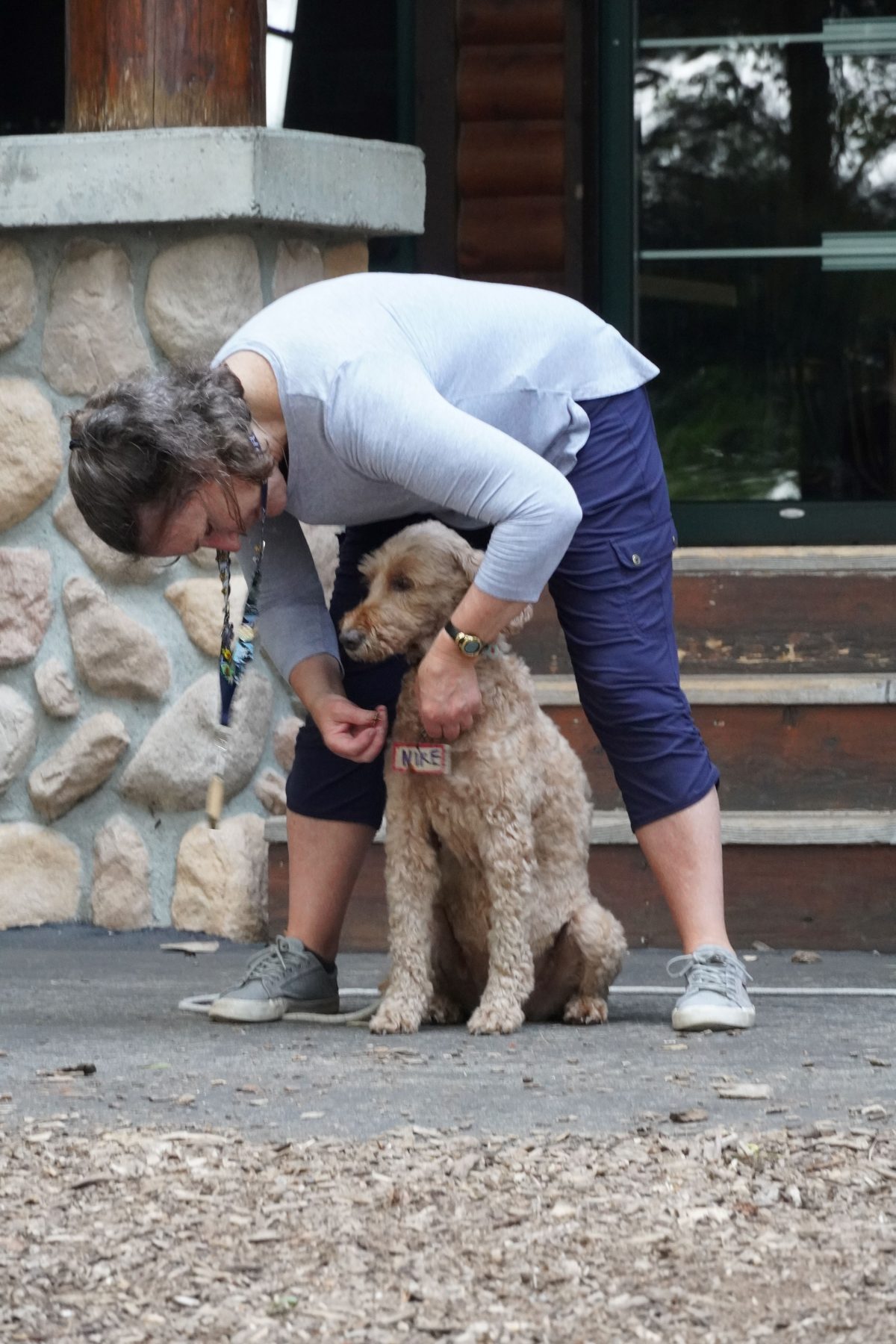 A woman pins a dog in the camp Foley pinning ceremony 