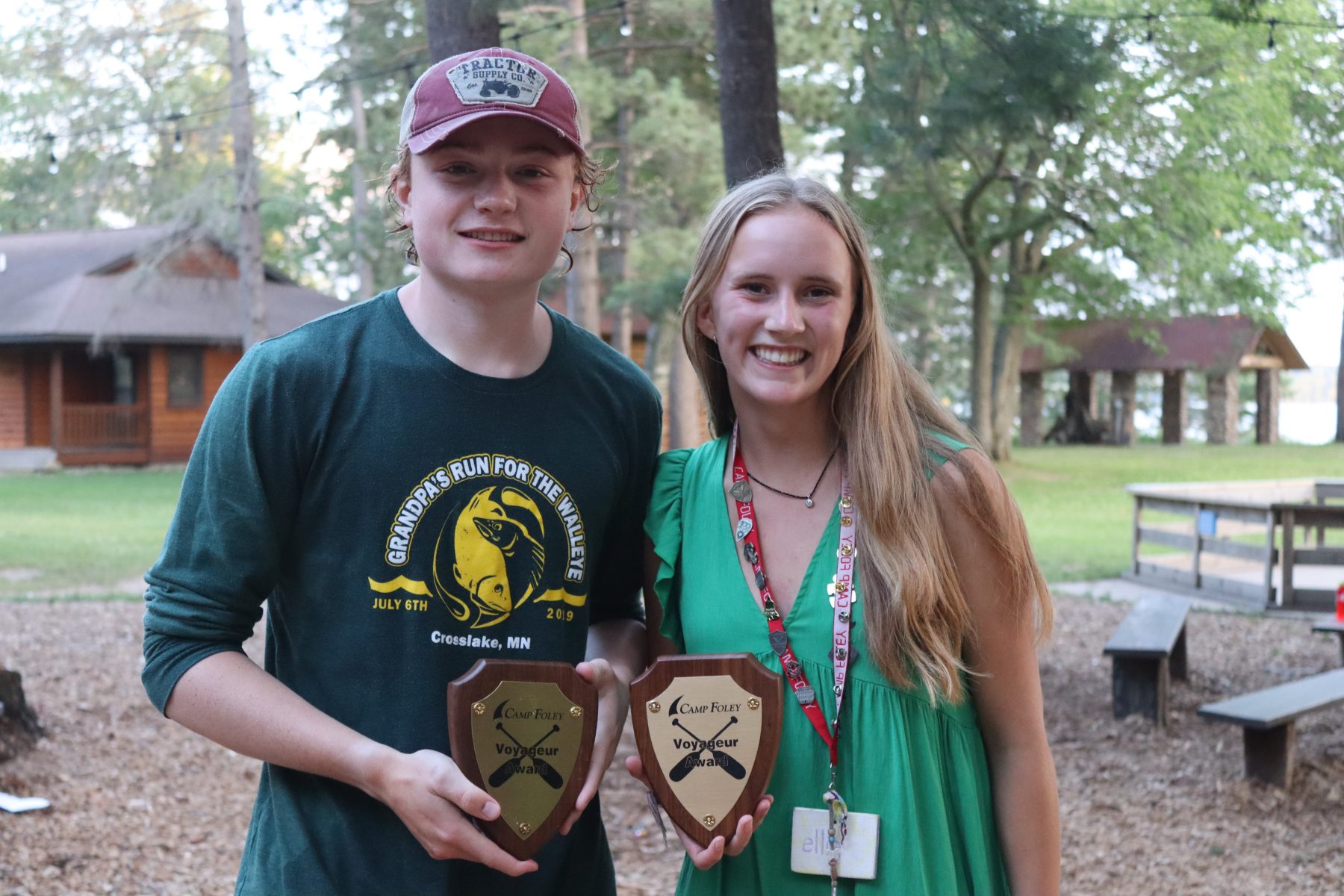 A girl and boy pose together at Camp Foley holding awards 