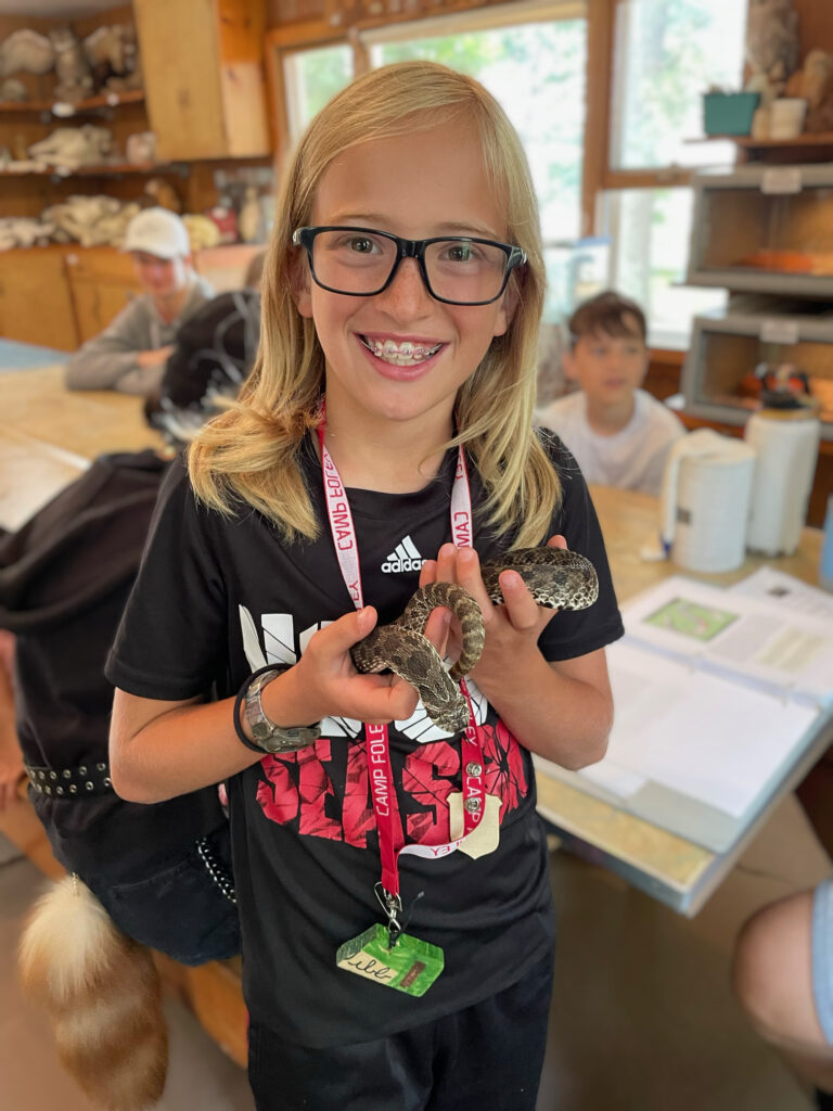 a camper at camp foley holds a hognose snake
