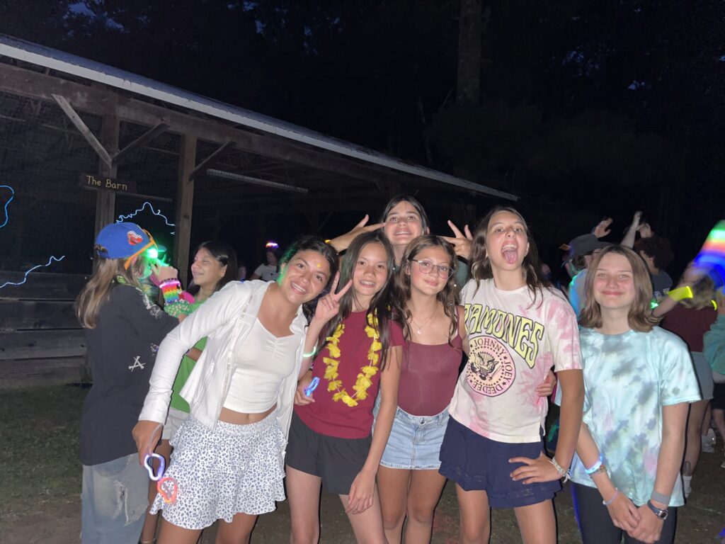 Foley campers pose together at a camp dance flashing peace signs 